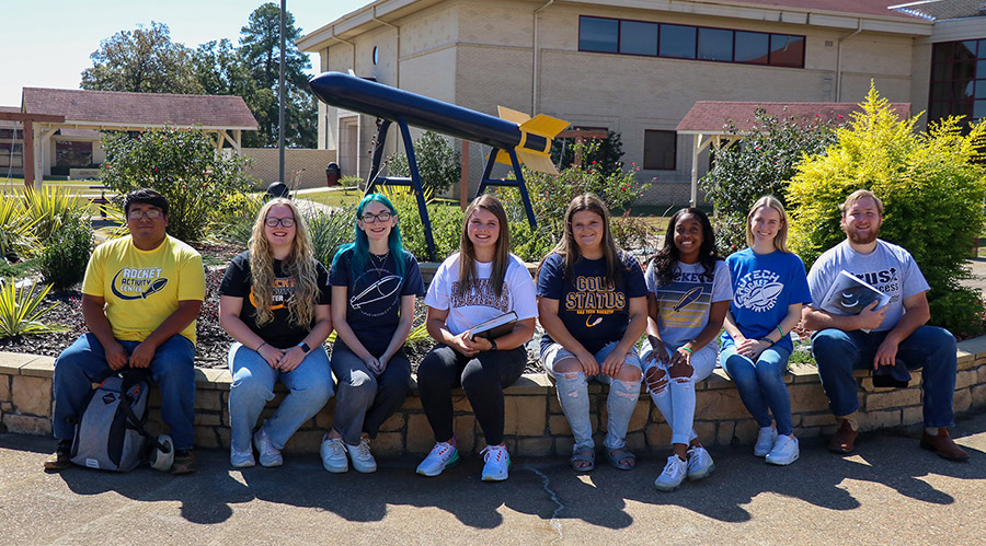 Students sitting in garden in front of rocet